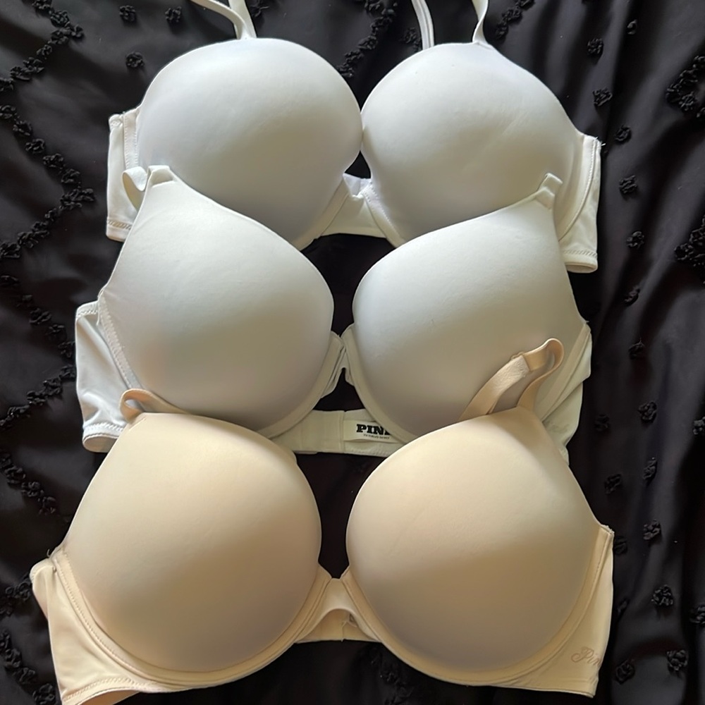 3 Victoria’s Secret adjustable strap bras 38C. 2 white, 1 beige.